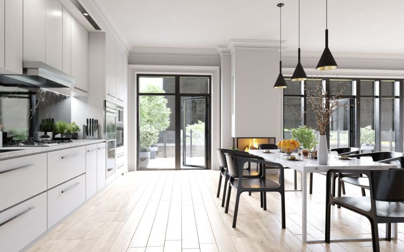 Cuisine très moderne avec grande table et chaises noires.