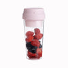 Mini blender portable en forme de gobelet avec des fruits à l'intérieur sur fond blanc