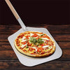 Pelle à pizza longue en métal avec un manche double en bois contenant une pizza sur une table en bois sur fond noir 